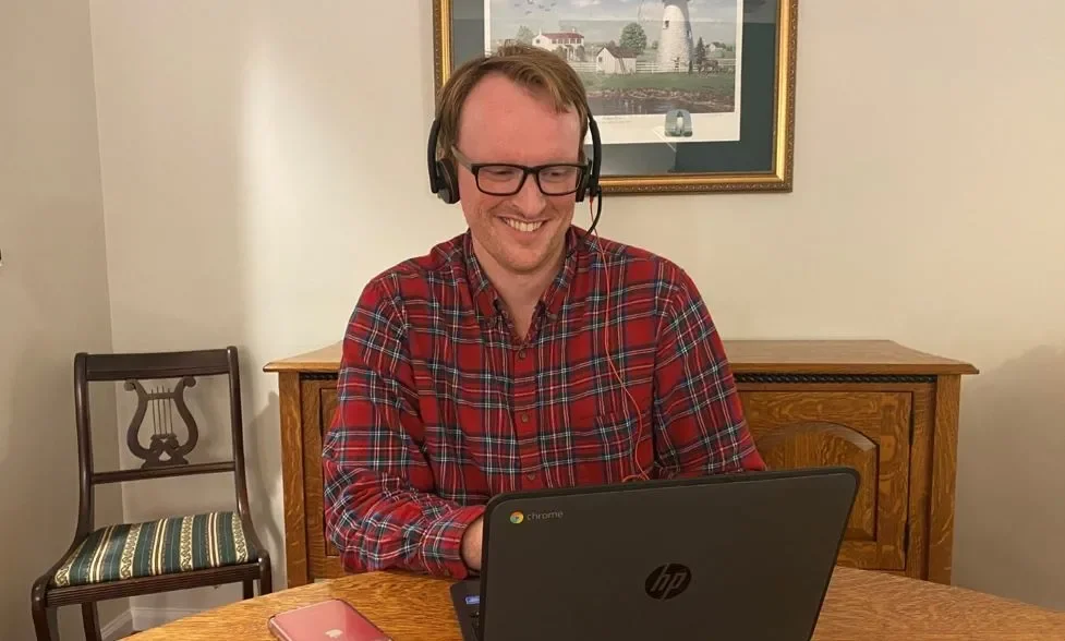 man in plaid shirt at laptop